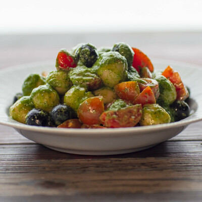 Gnocchi di pane con pesto di rucola, pomodorini e olive